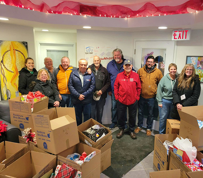 Rotary Club team photo in front of Christmas Hamper donation boxes