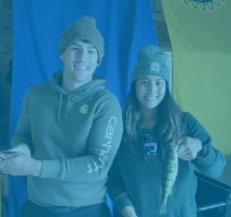 Photo of two people with a fish at event